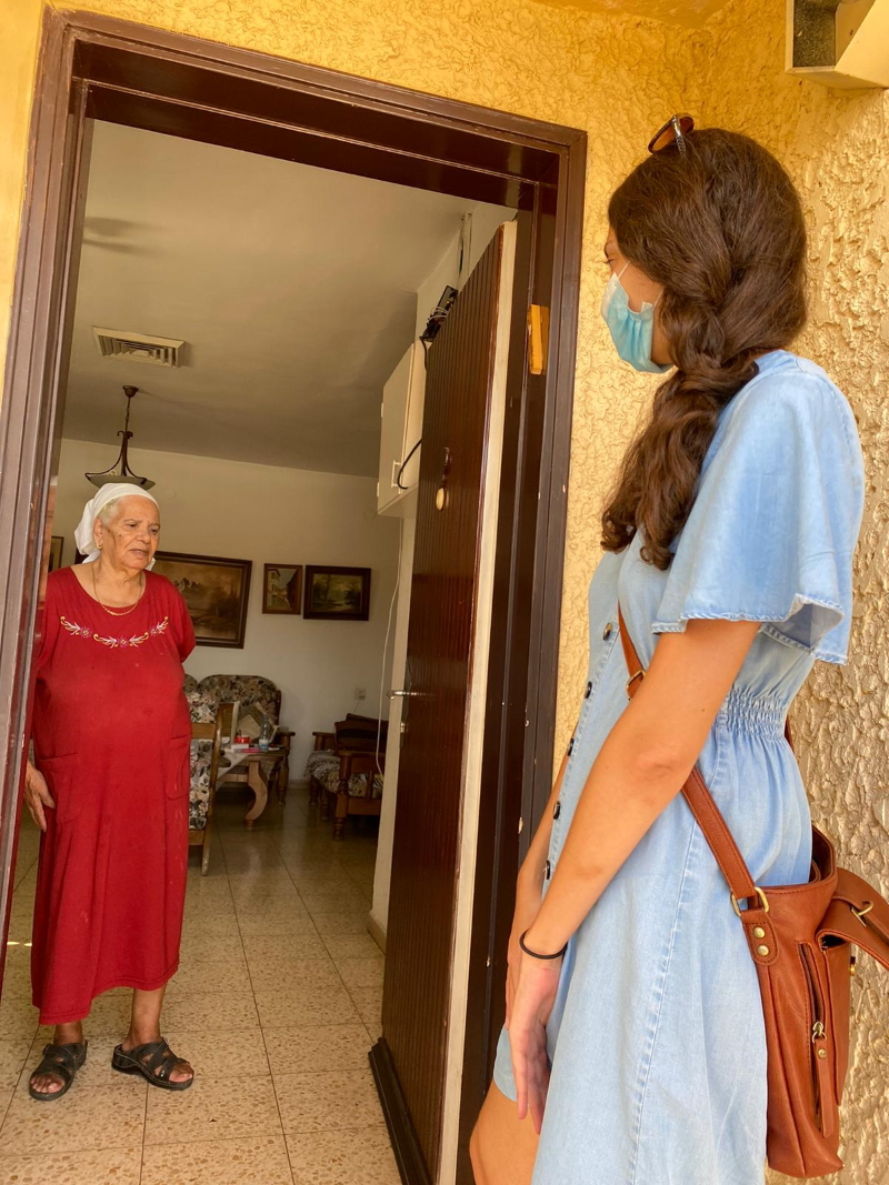 מתנדבת בביקור אצל קשישים בעיר