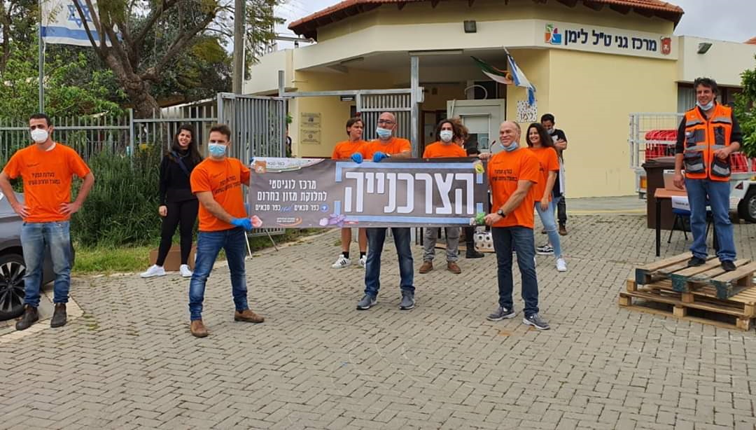 המתנדבים עם שלט הצרכנייה