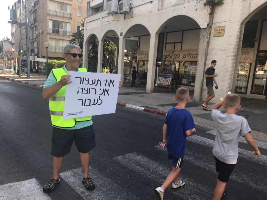 מעביר דרך בפעולה מחזיק שלט עם הכיתוב אחי תעצור אני רוצה לעבור