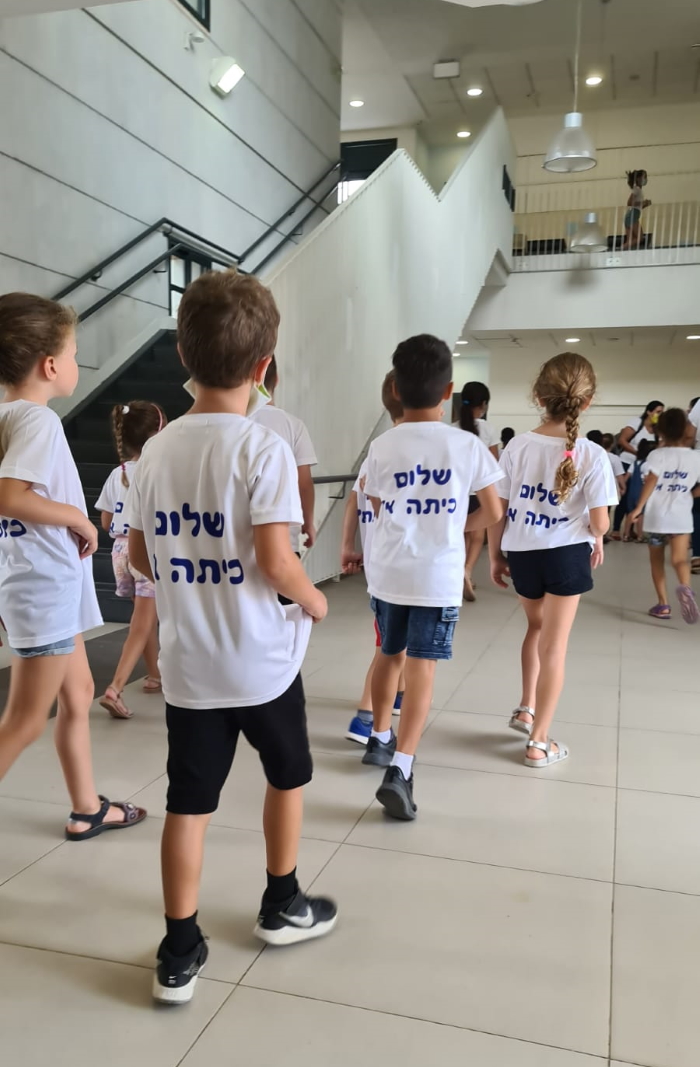 תלמידים בית הספר לובשים חולצות עם הכיתוב שלום כיתה א