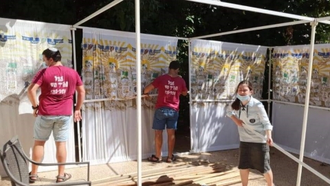 בני הנוער מסייעים בבניית סוכה