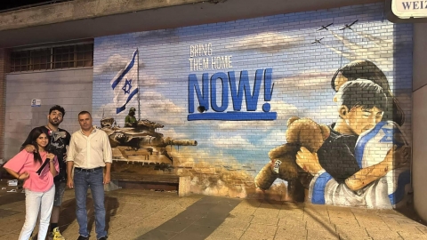 ראש העיר רפי סער האומן דודי שובל ולורן אליהו מכפר סבא לצד ציור הקיר הקורא להשבת החטופים
