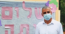 ראש העיר רפי סער בסמוך לשלט עם הכיתוב שלום כיתה א
